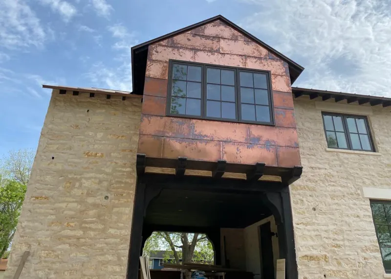 Copper metal panel facade on a stone building for Skylight Installation in Hamlin