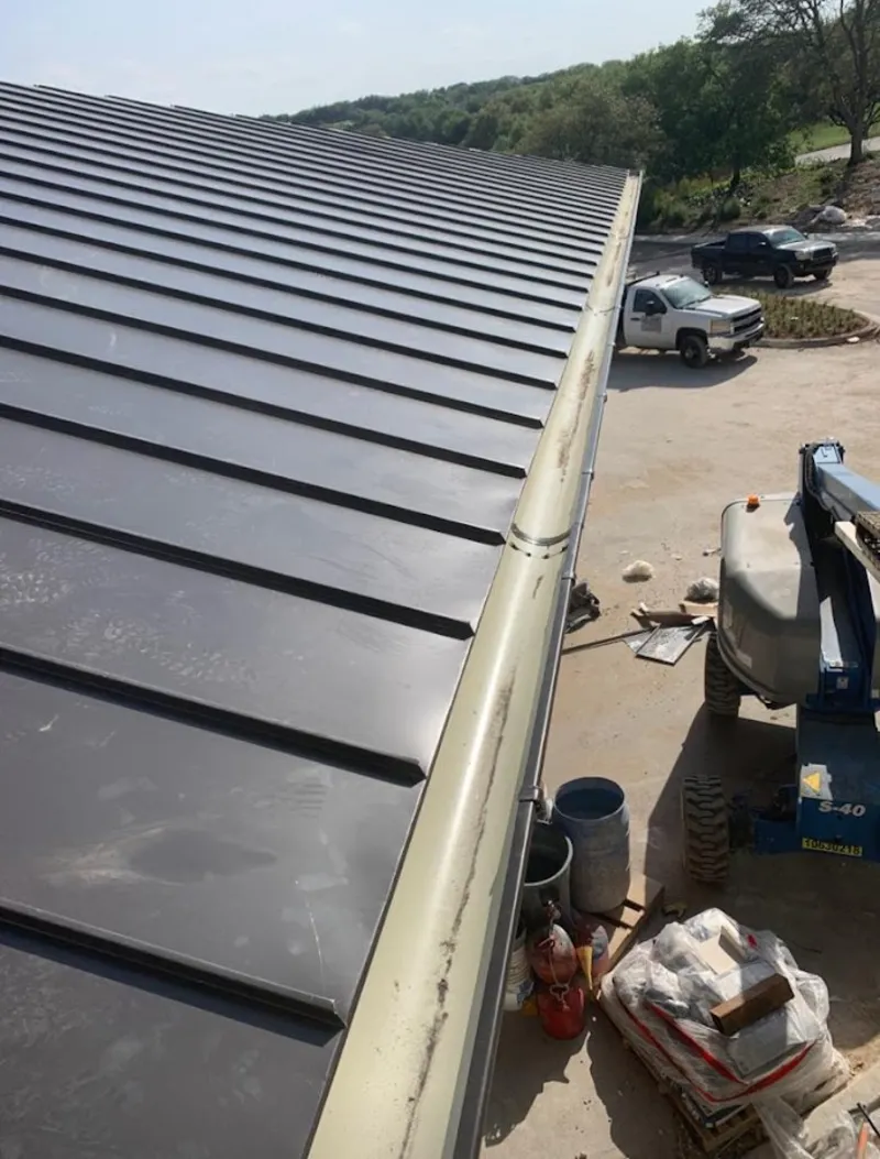 Standing seam panel and gutter detail on a metal roofing jobsite in Hamlin
